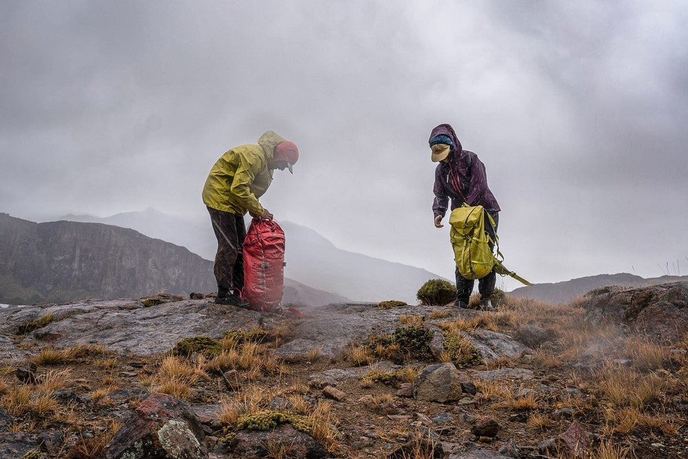hikers wearing patagonia backpacks under the rain