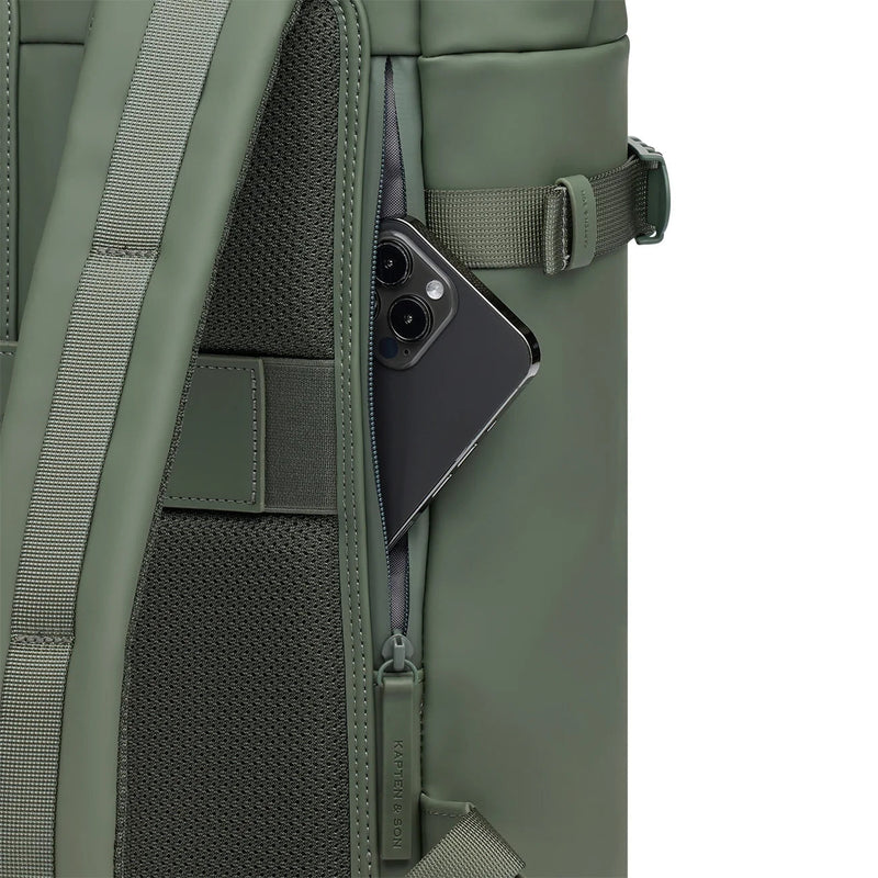 Phone in the anti-theft pocket at the edge of the back panel of the dusty green Helsinki