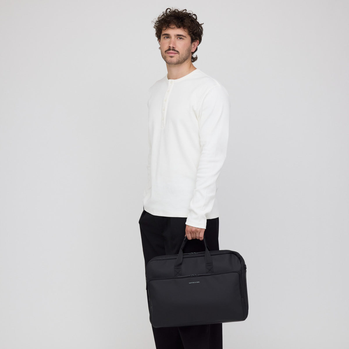 Man carrying the Bodo Laptop Bag by its handles