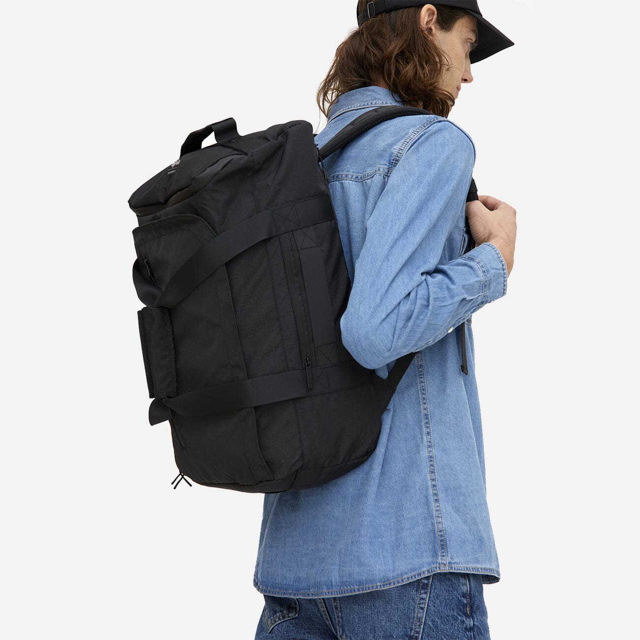 man wearing black eco conscious backpack side view