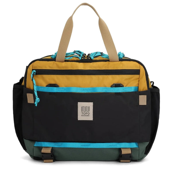 Topo Designs Mountain Cross Bag 17L in mustard and forest — front view with mustard yellow body and teal pocket