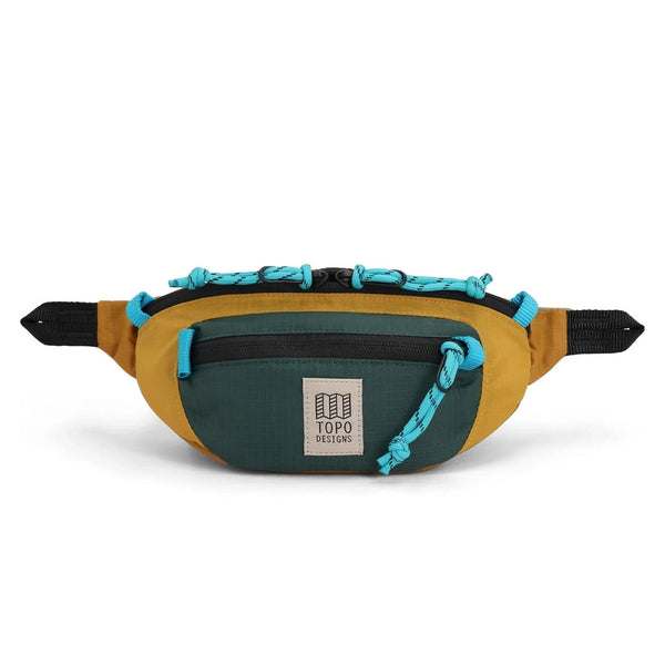 Topo Designs Mountain Waist Pack 1L in mustard and forest — front view with mustard yellow body and teal pocket