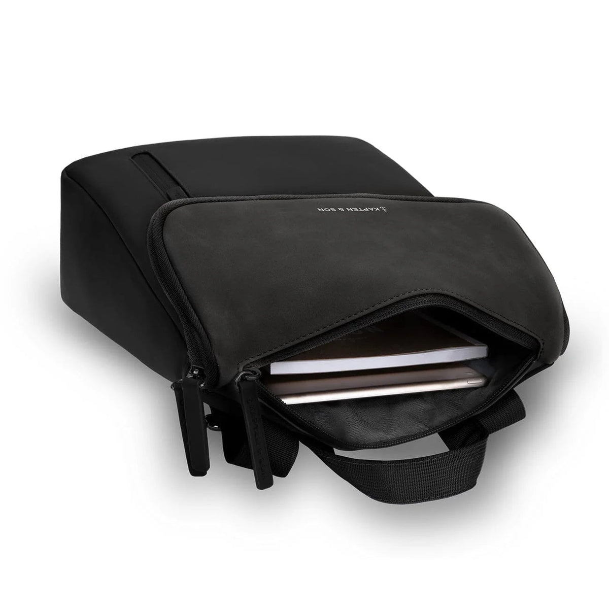 Top-down view of the black Vallen with the main compartment open, a notebook and a tablet inside