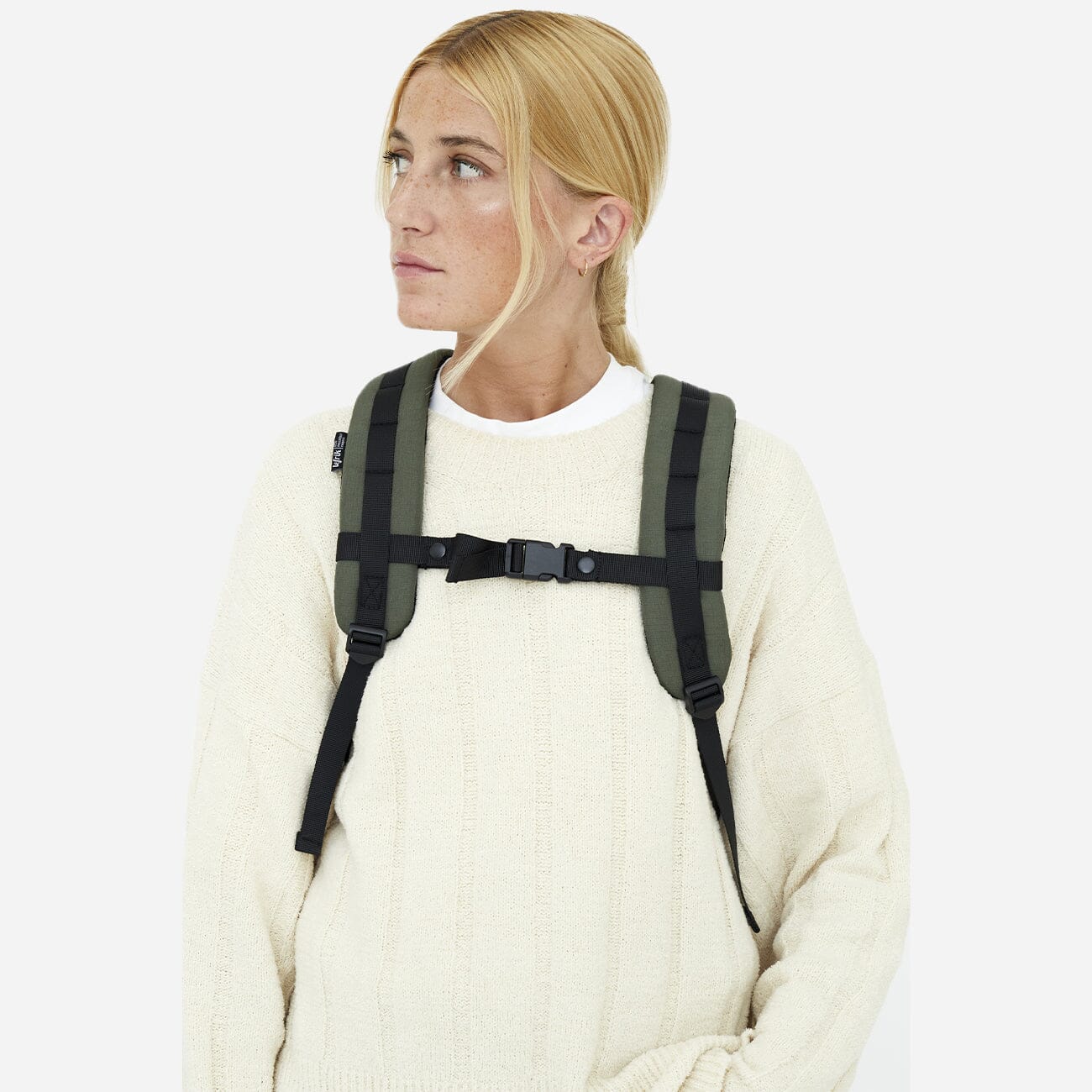 woman wearing green sustainable backpack sternum belt close up
