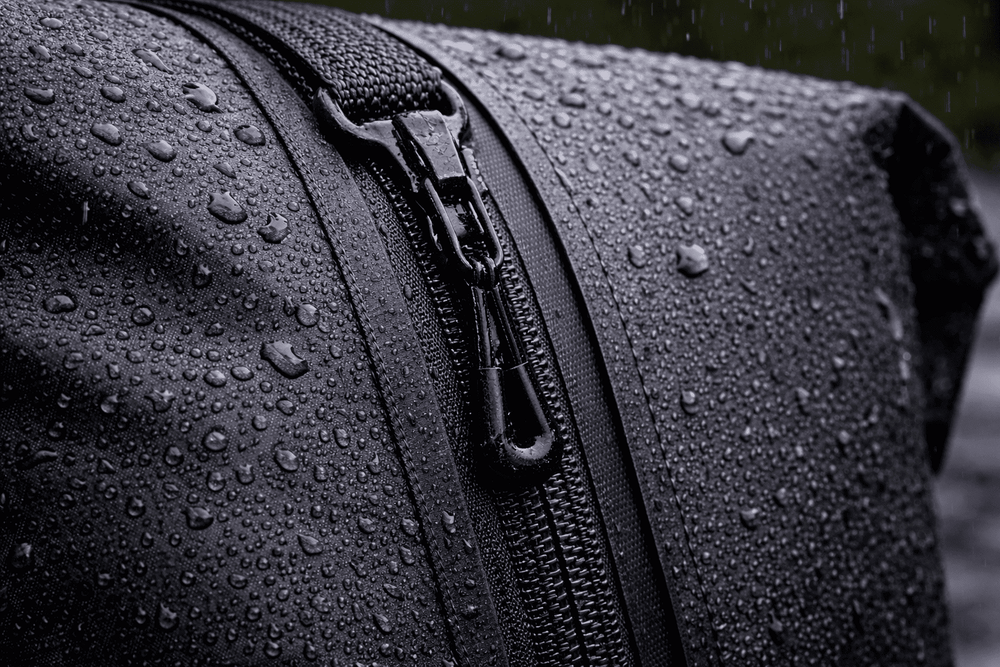 Close-up of a waterproof backpack zipper with water droplets