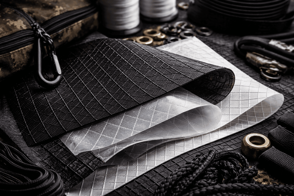 Close-up of X-Pac laminated fabric used for technical backpacks, showing X-Ply reinforcement grid and waterproof structure