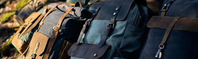 vintage travel full grain leather and cotton canvas rucksack backpacks for men and women laying on the floor