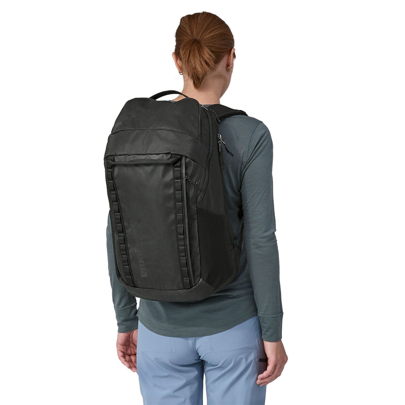woman model wearing the Black Hole Pack 32L in Black, back view