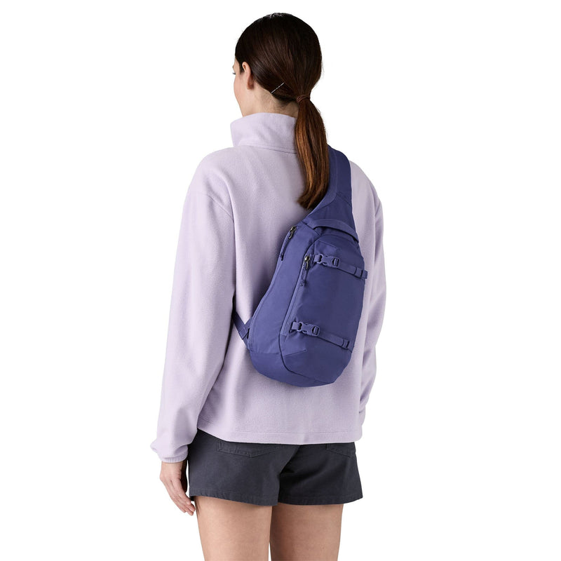 woman model wearing the Atom Sling 8L in solstice purple, back view