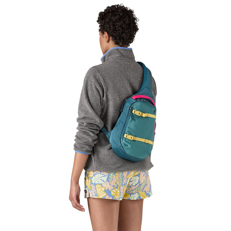 woman model wearing the Atom Sling 8L in wetland blue, back view