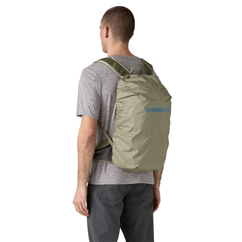 man wearing Patagonia, terravia pack 22L in rover rock green, back view, integrated rain cover