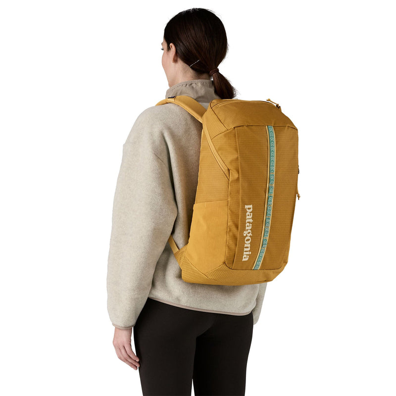 woman model wearing the Black Hole Pack 25L in Pufferfish Gold, back view