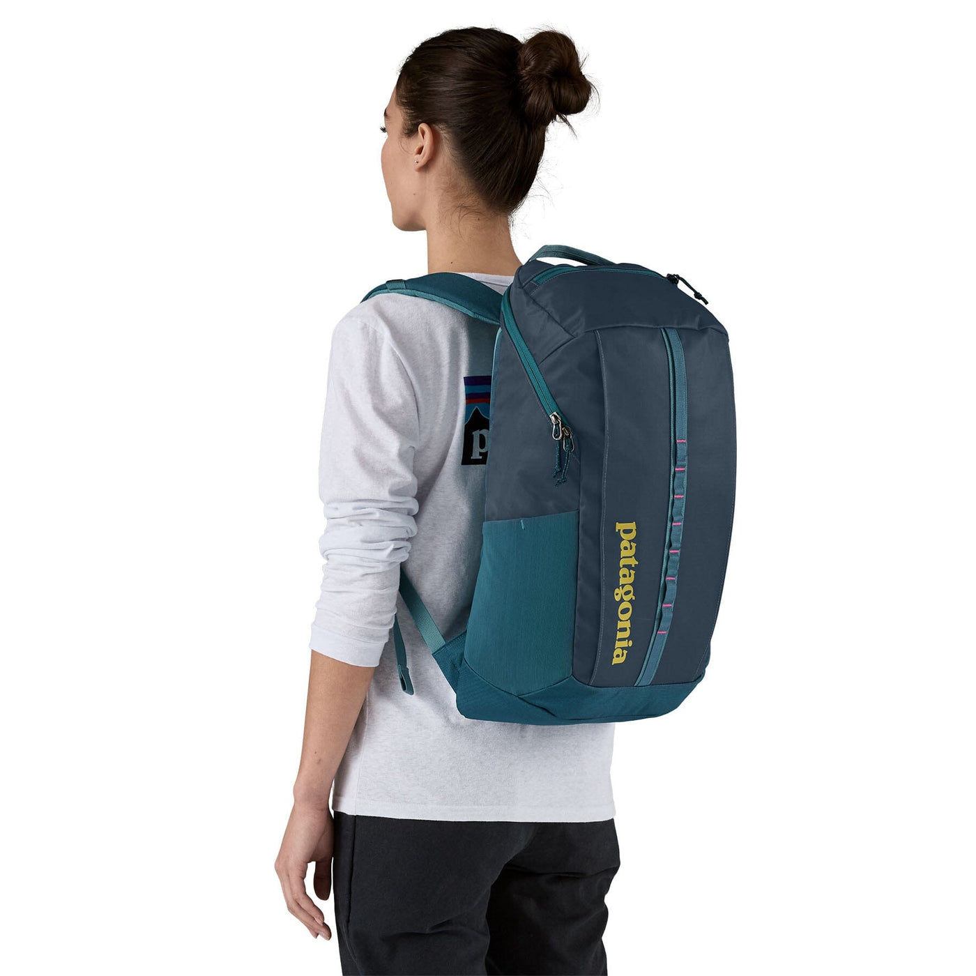 woman model wearing the Black Hole Pack 25L in tidal teal, front view