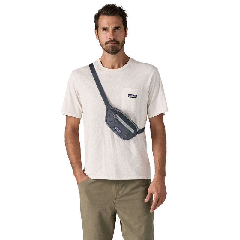 man model wearing the Terravia Mini Hip Pack in smolder blue as a crossbody bag