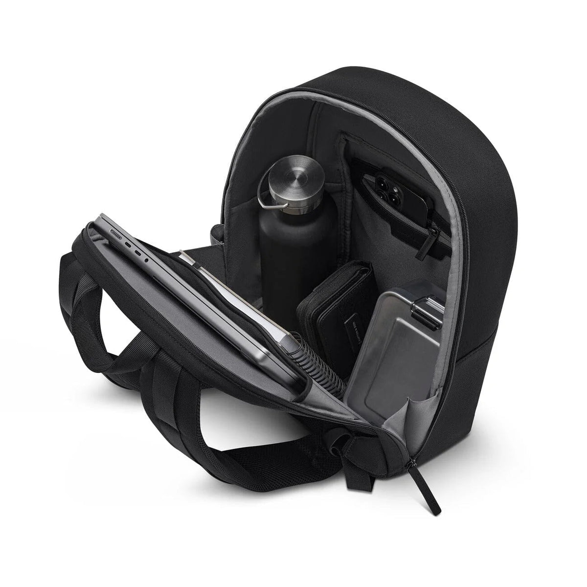 Back panel folded open and packed: laptop and notebook in the sleeve, water bottle, phone in the zip pocket