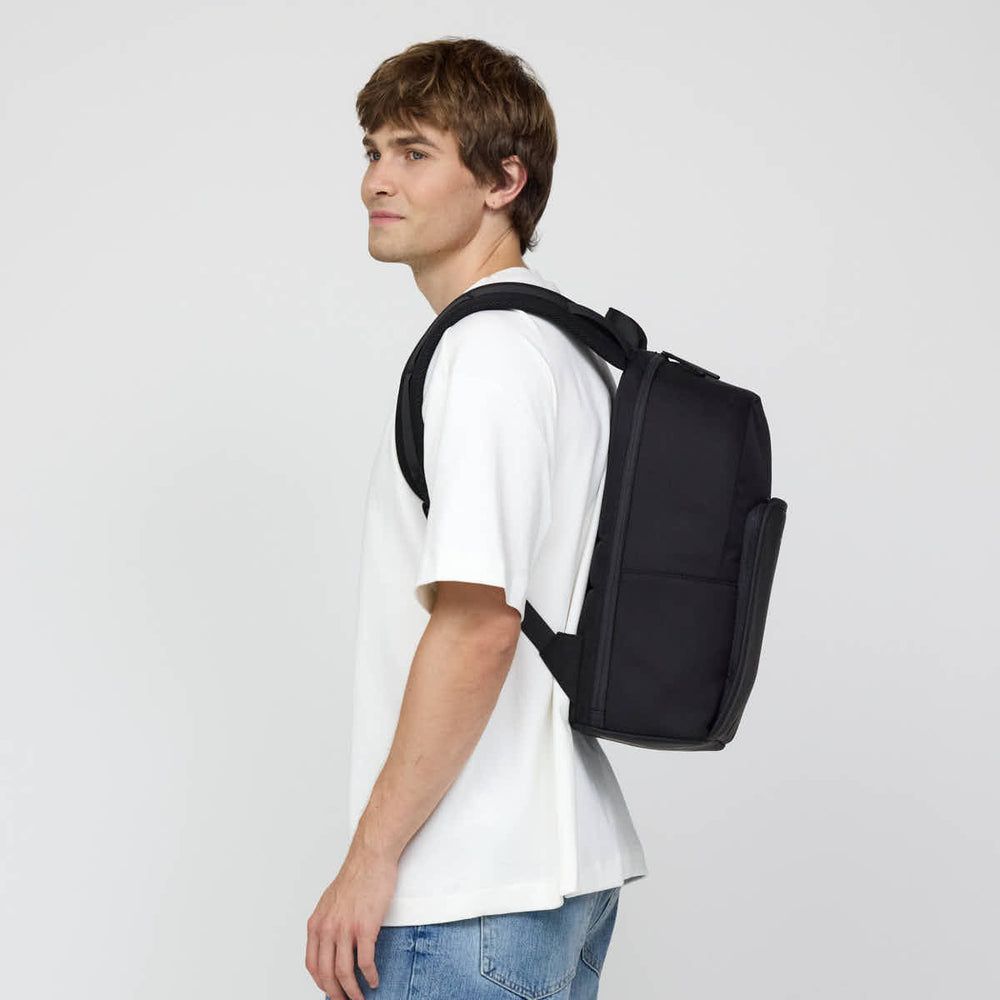 Felix, 1.85&nbsp;m, wearing the black Kapten & Son Aalborg backpack, side view