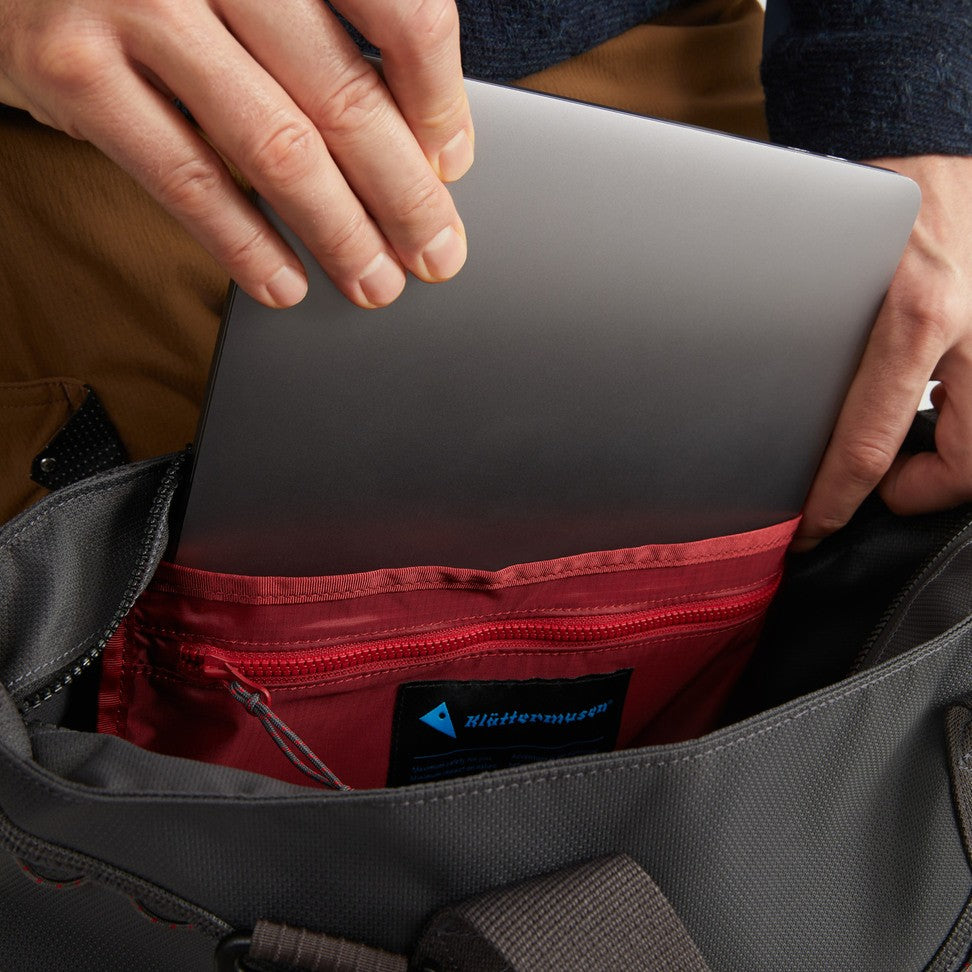 Laptop slid into the padded sleeve inside the Baggi Bag 22L in Raven