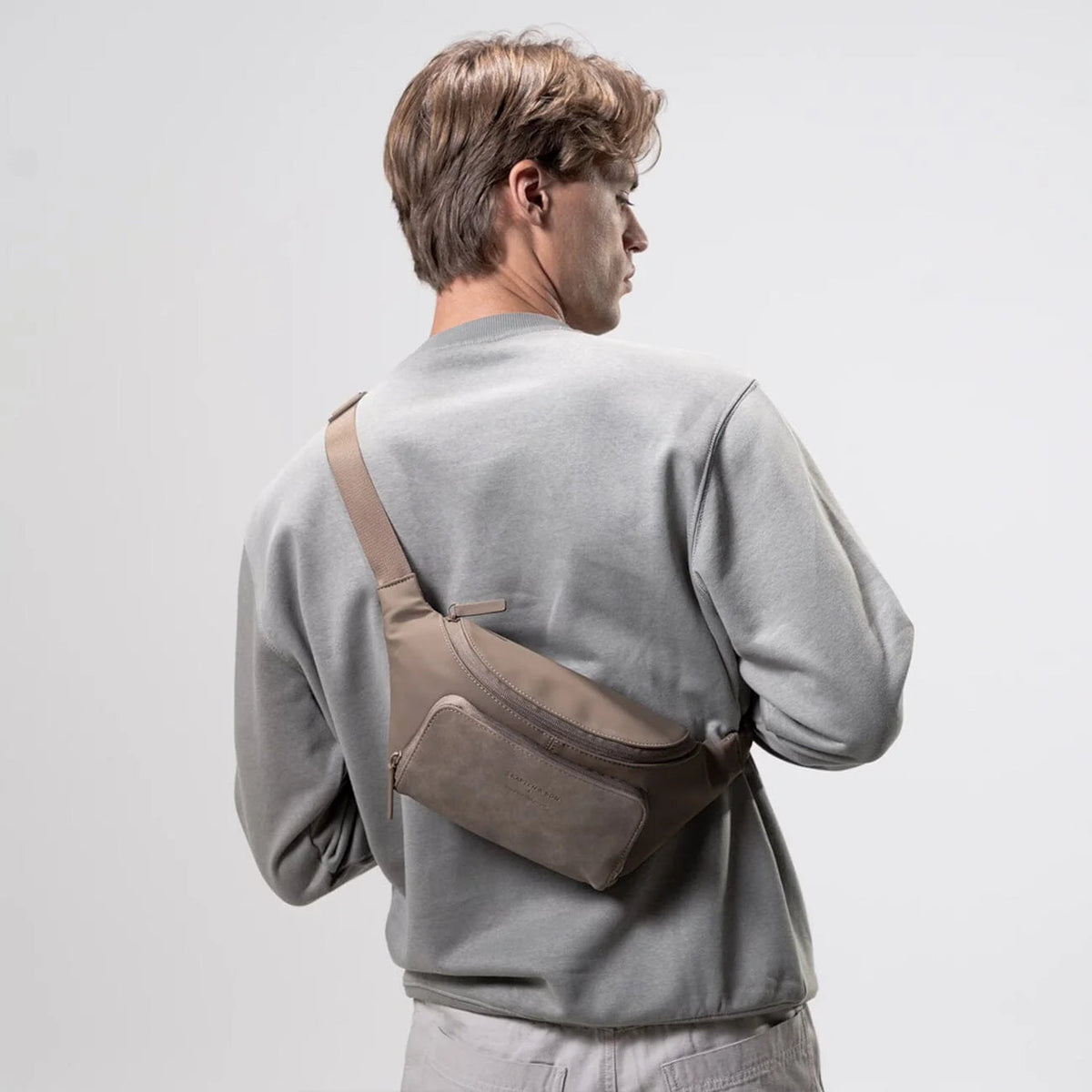 Man wearing the walnut Bali crossbody across his back, casual look