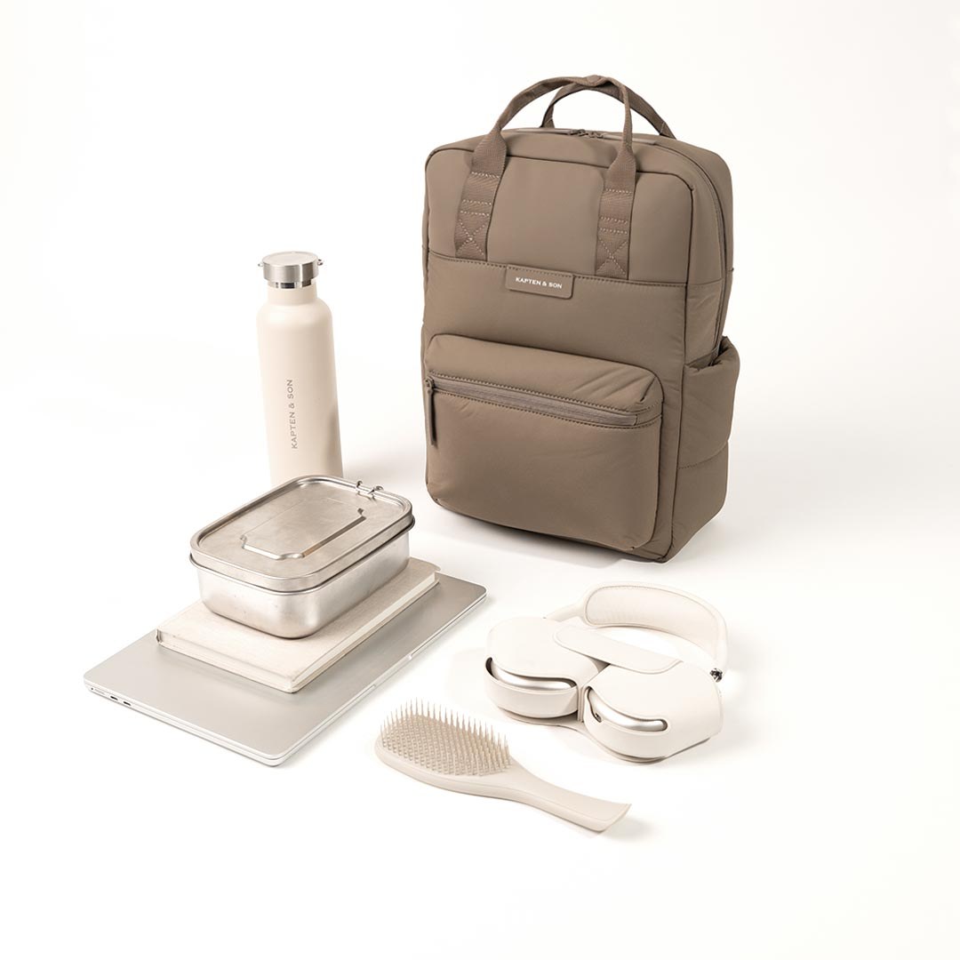 Bergen Cloud walnut backpack styled with a water bottle, lunch box and headphones it fits
