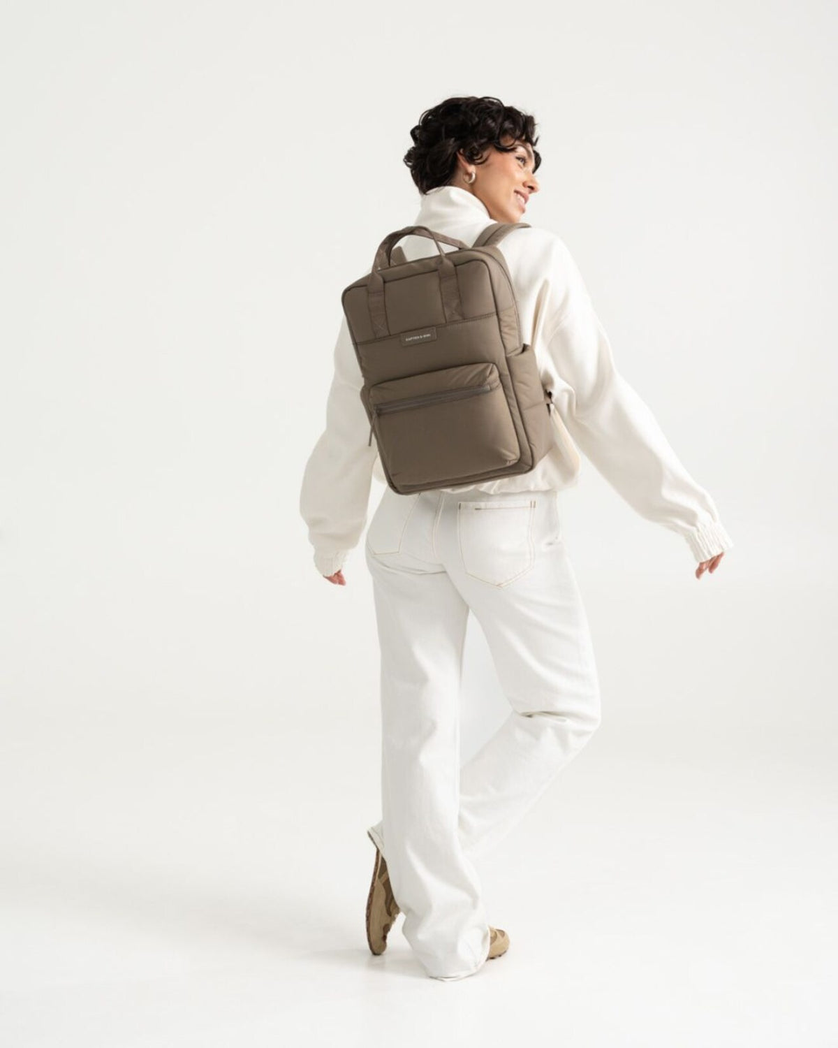 Woman walking away, wearing the walnut Kapten & Son Bergen Cloud backpack