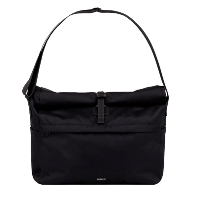 Sleek black messenger bag worn crossbody, ideal for commuting with a laptop and everyday essentials