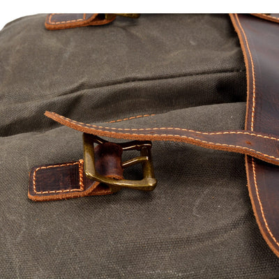 close up of the leather straps, brass buckle and sturdy stitching of the vintage messenger bag from eiken, tulsa model