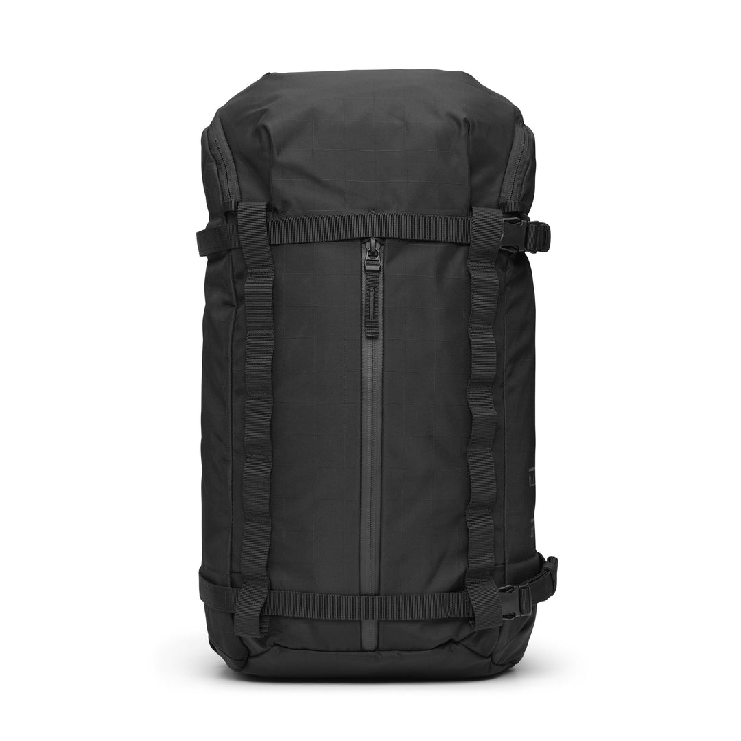 DB Journey Backcountry Backpack 20L in Black, front view with the vertical zip pocket, compression straps and ripstop shell