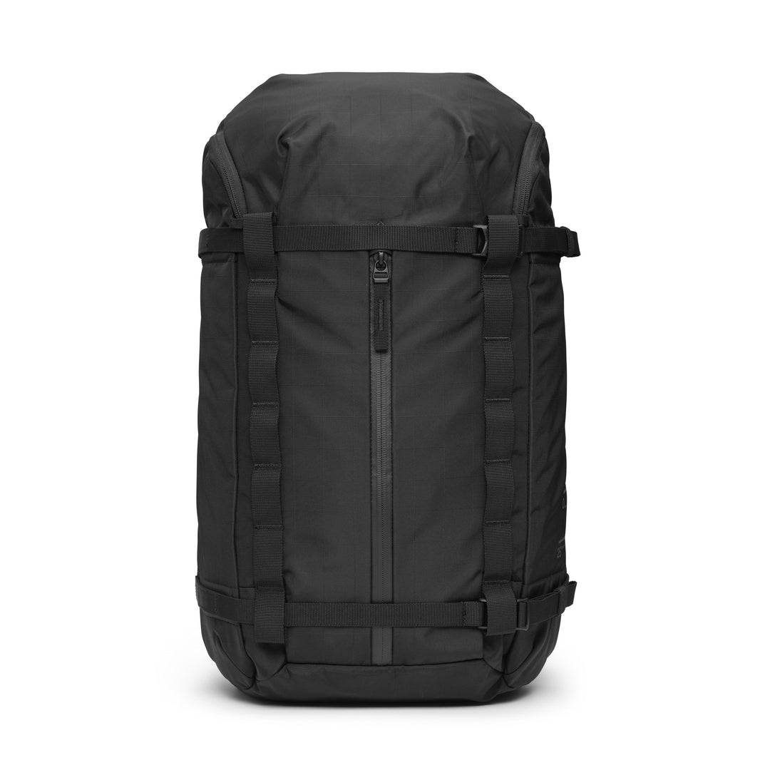 DB Journey Backcountry Backpack 25L in Black, front view with the vertical zip pocket, compression straps and ripstop shell