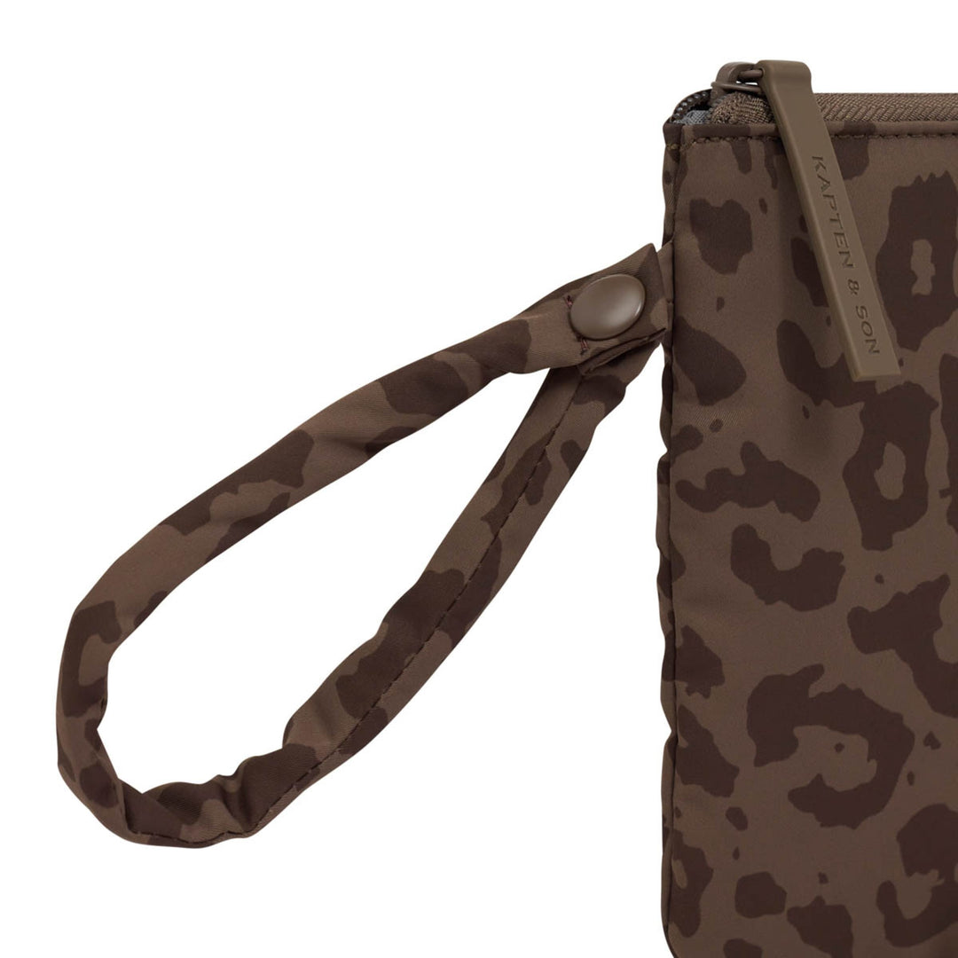 Detail der gepolsterten Handschlaufe und des Druckknopfs der Essentials Pouch Leo Dark Brown