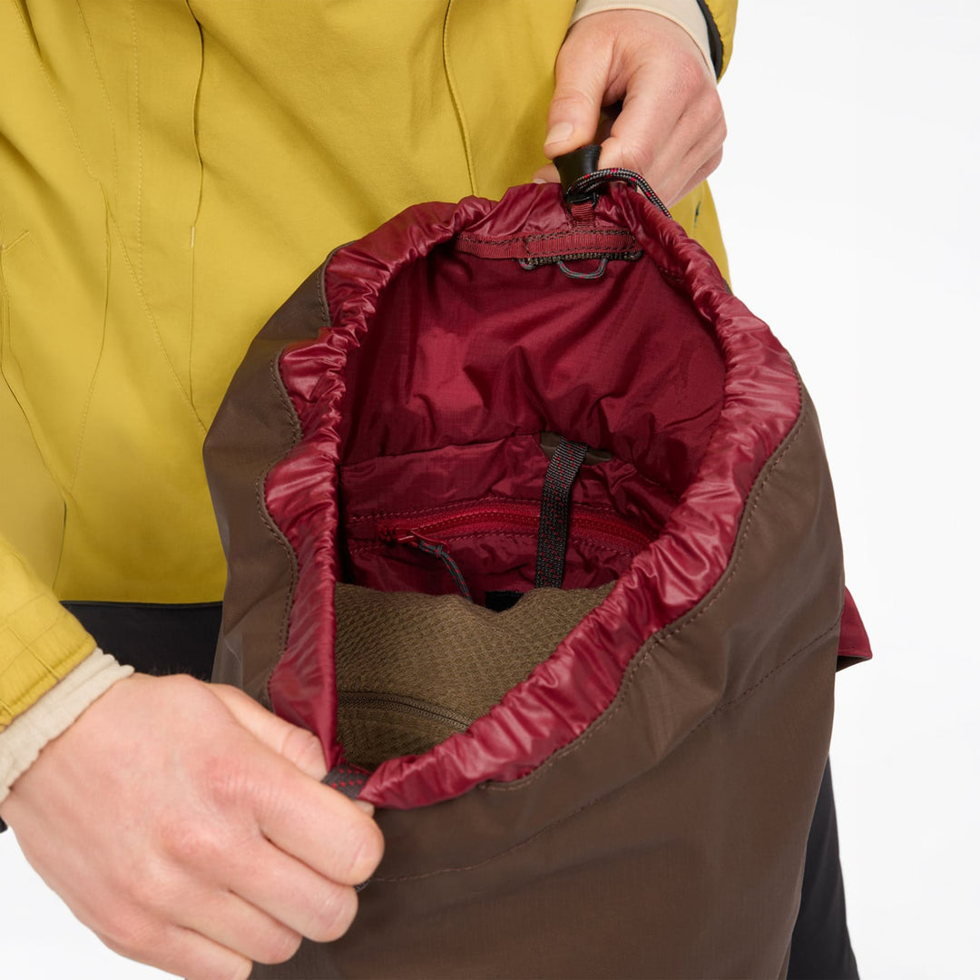 Fjörm 18L with the lid open — red drawcord collar of the main compartment, Slate Brown version