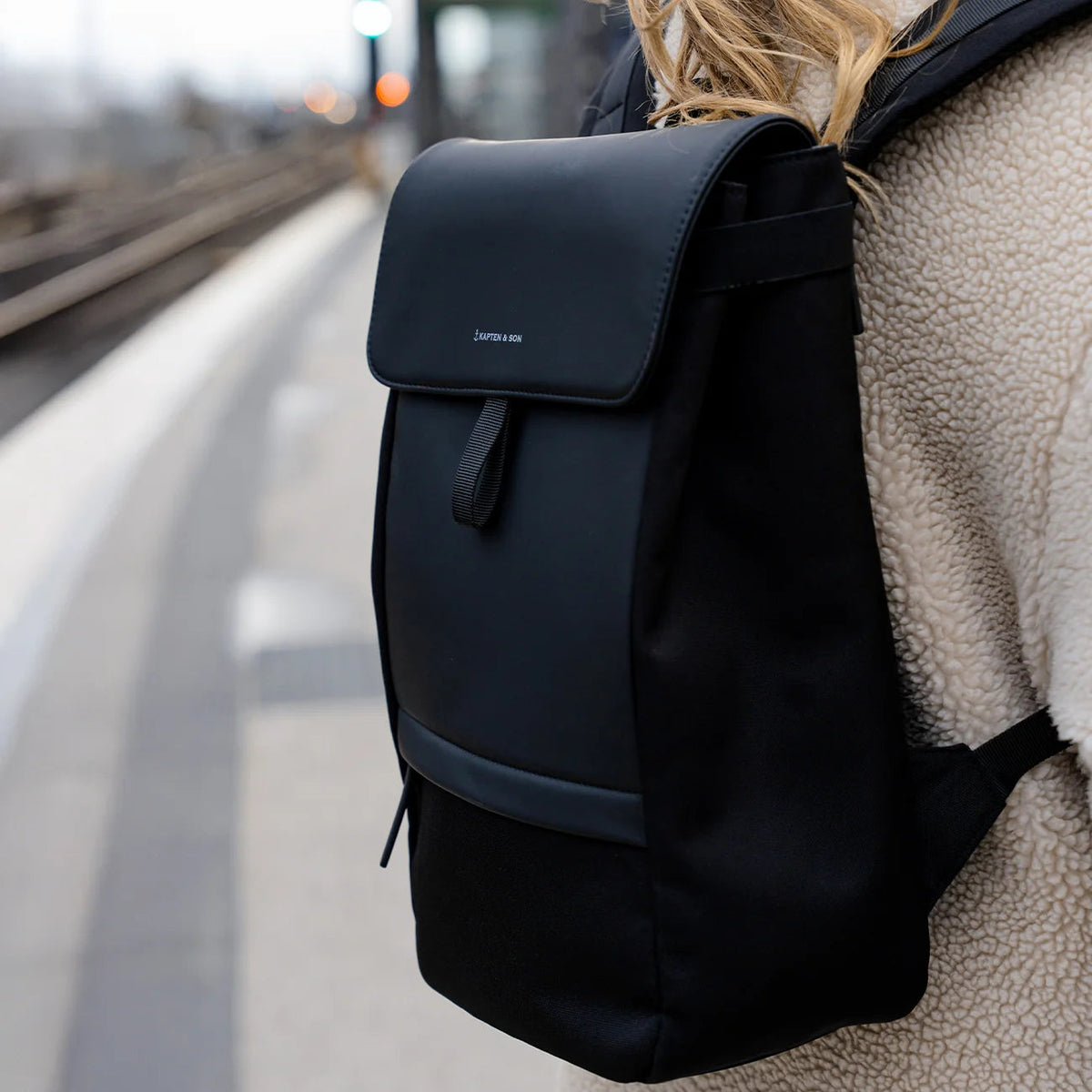 Close-up of the black Fyn on a woman at a train station