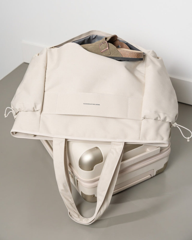 Sandstone Hellvi Pro Large slid over the handle of a suitcase