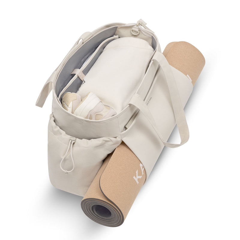 Cork yoga mat slid horizontally through the double front layer of the sandstone Hellvi Pro Large