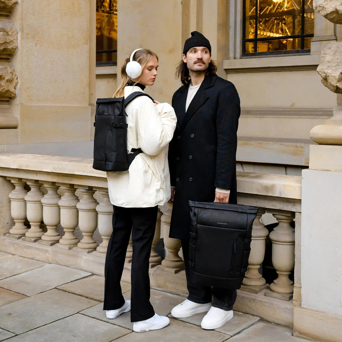 Woman wearing the black Kapten & Son Helsinki Pro in the city, a man holding a second one