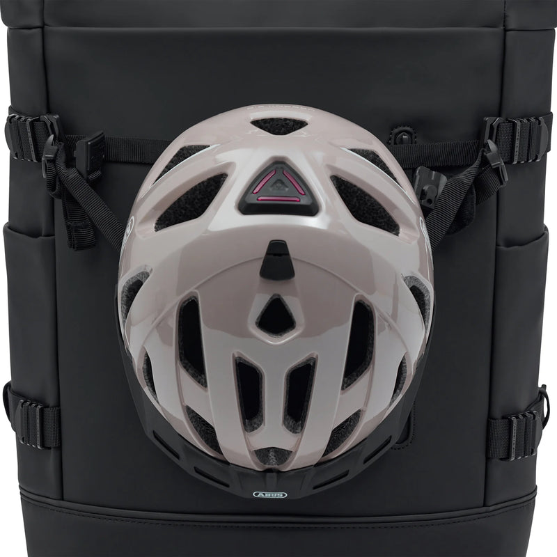 Helmet held on the front of the black bag by two straps clipped to the side buckles