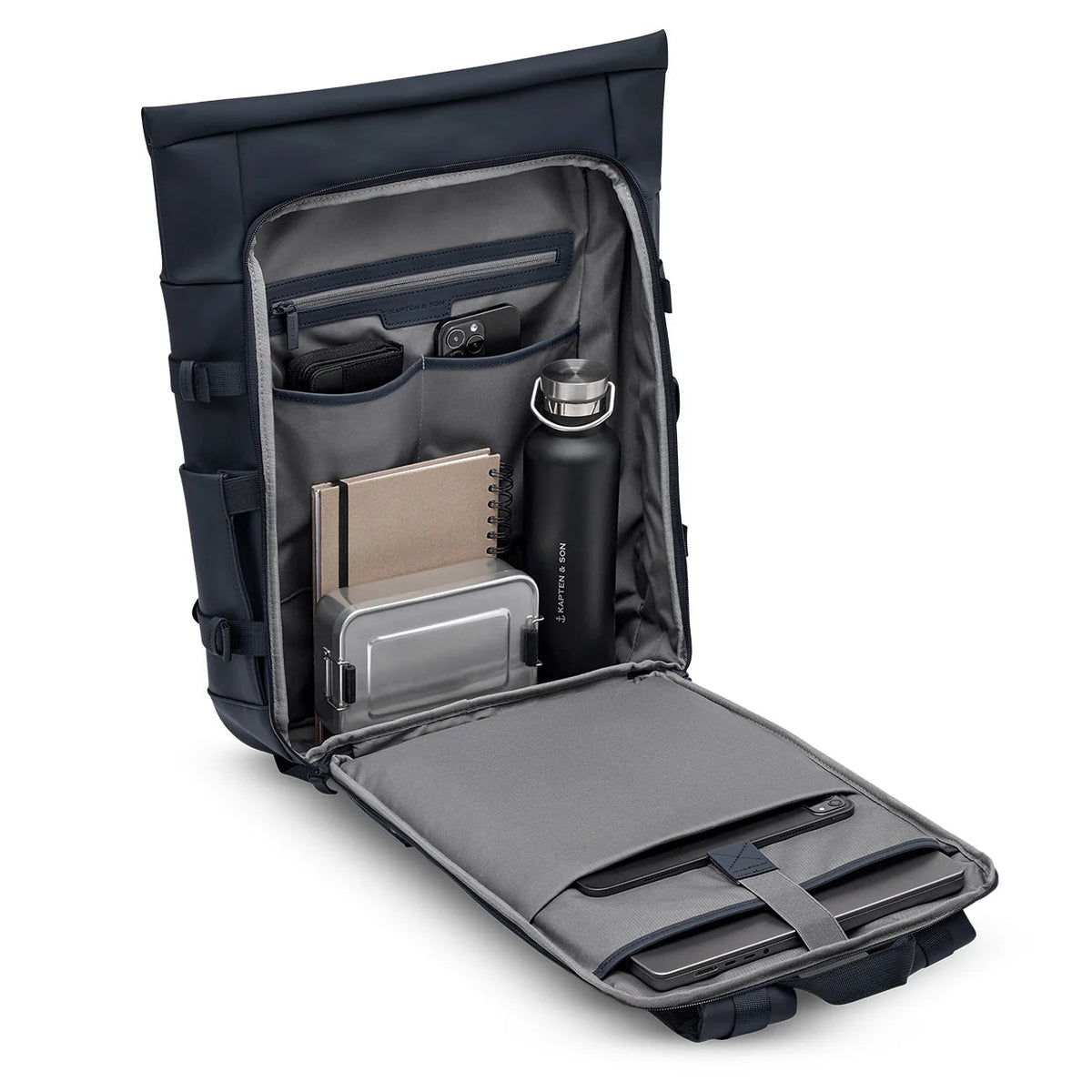 Navy Helsinki Pro opened flat and packed with a laptop, notebooks, a lunch box and a bottle