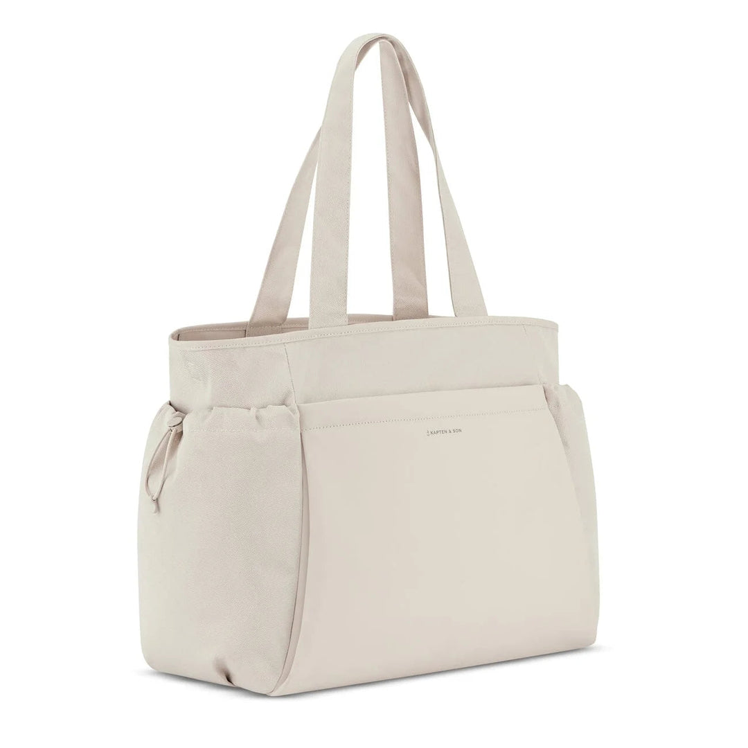 Side angle showing drawstring pocket and logo — sandstone