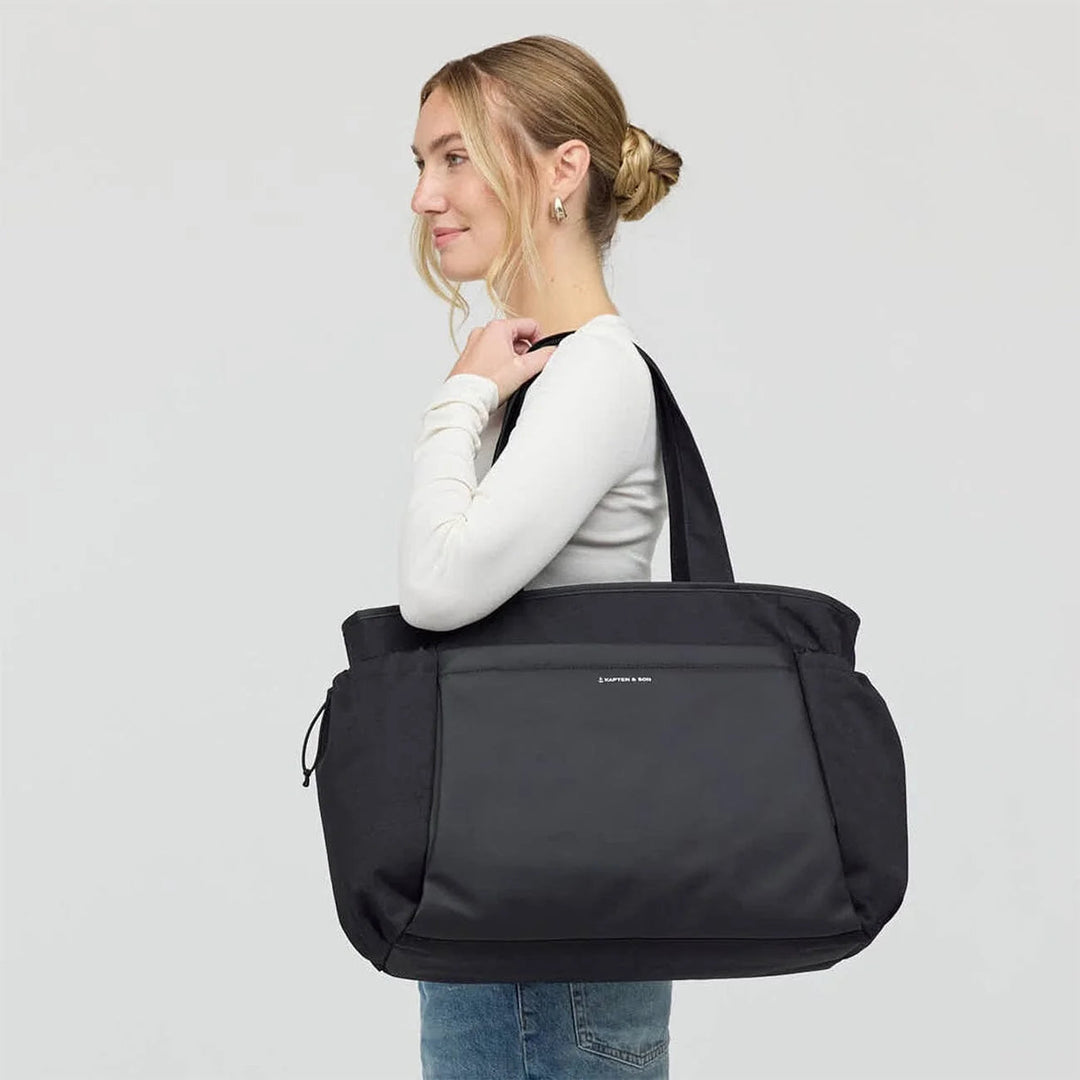 Woman carrying the Hellvi Pro Large black tote on shoulder — casual outfit
