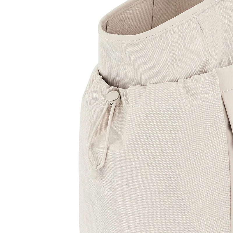 Drawstring side pocket close-up with toggle closure — sandstone