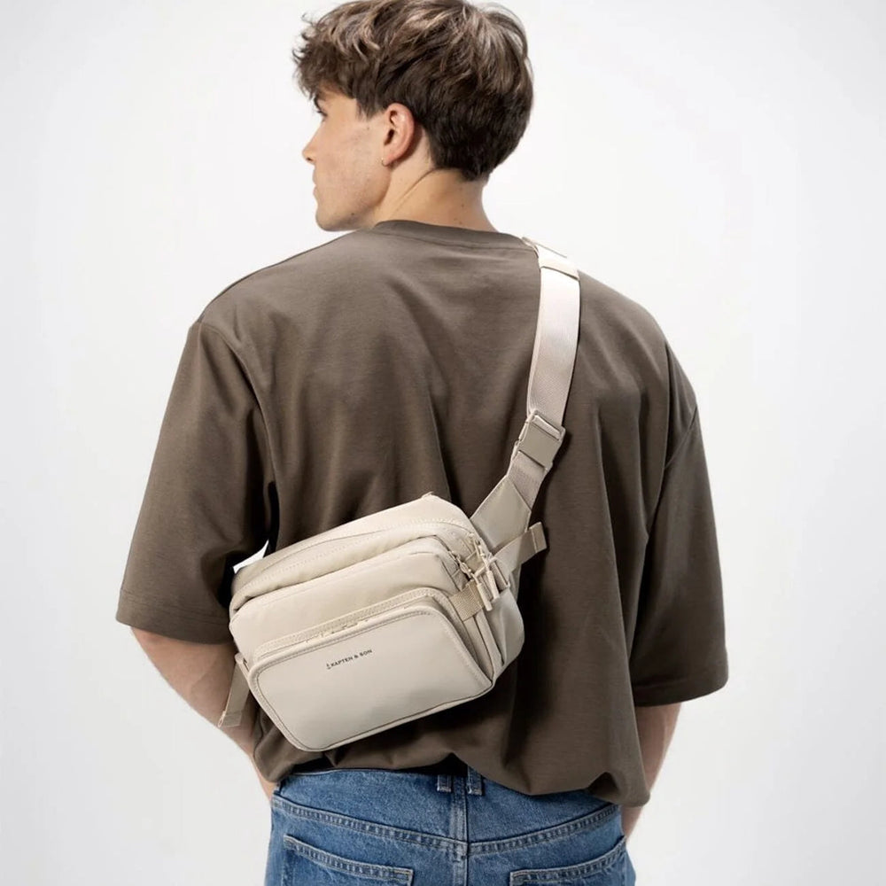 Man wearing the Lisbon sandstone crossbody across the back, rear view