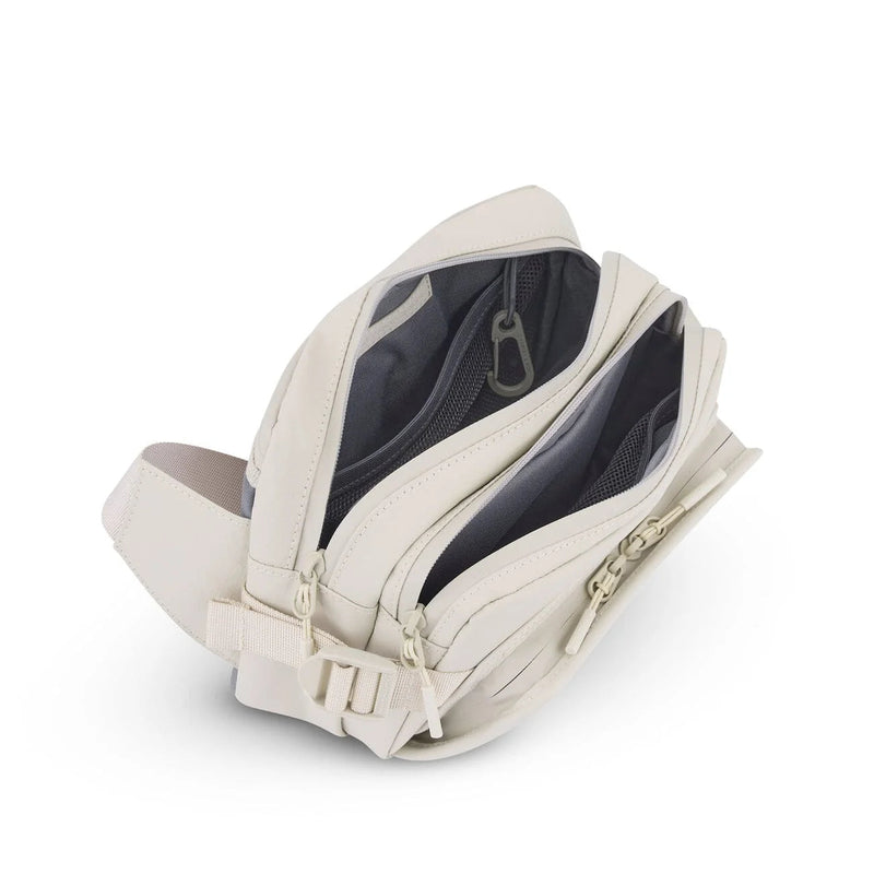 Both main compartments open, mesh pockets and key carabiner, sandstone