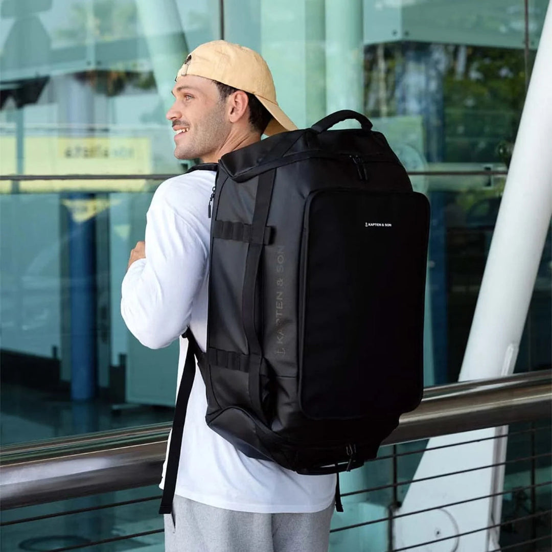 Man wearing the Lisbon Large duffle as a backpack at the airport
