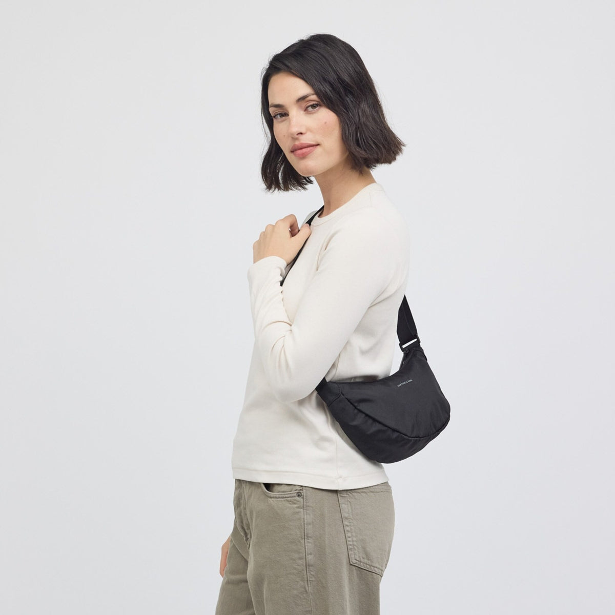 Woman wearing the black Essential Moon Bag on the shoulder