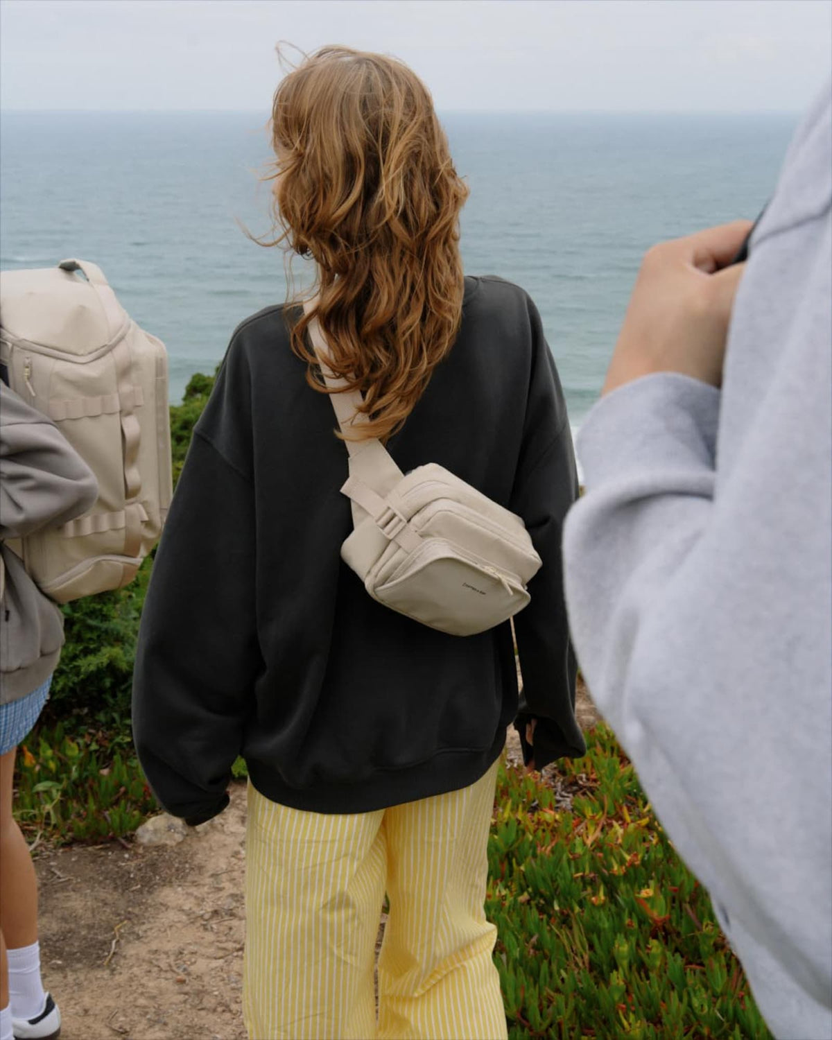 Woman seen from behind wearing the sandstone Lisbon Crossbody on her back