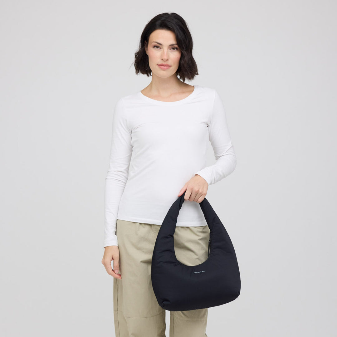 Woman holding the black Skara Cloud Shoulder by its handle