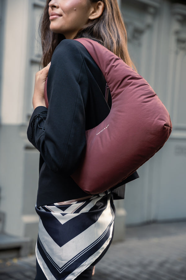 Close-up of the burgundy Skara Cloud Shoulder worn on the shoulder