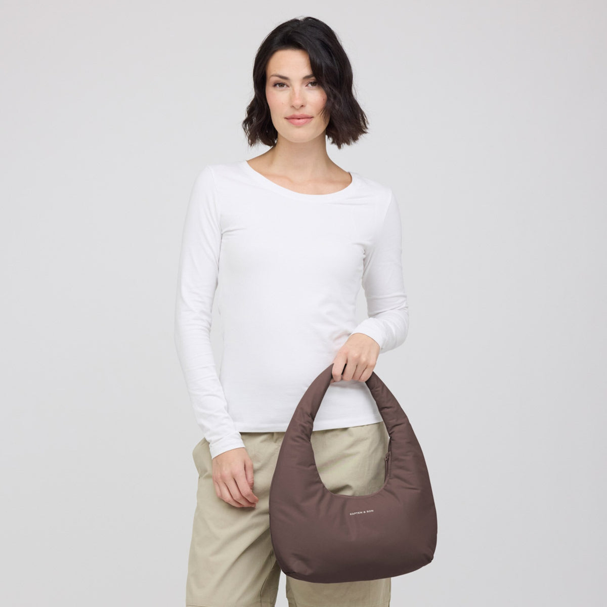 Woman holding the chocolate brown Skara Cloud Shoulder by its handle
