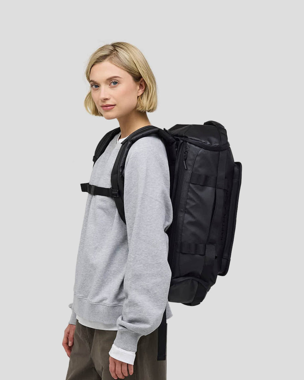 Emma, 1.72&nbsp;m, wearing the black Lisbon Duffle Backpack Small, side view
