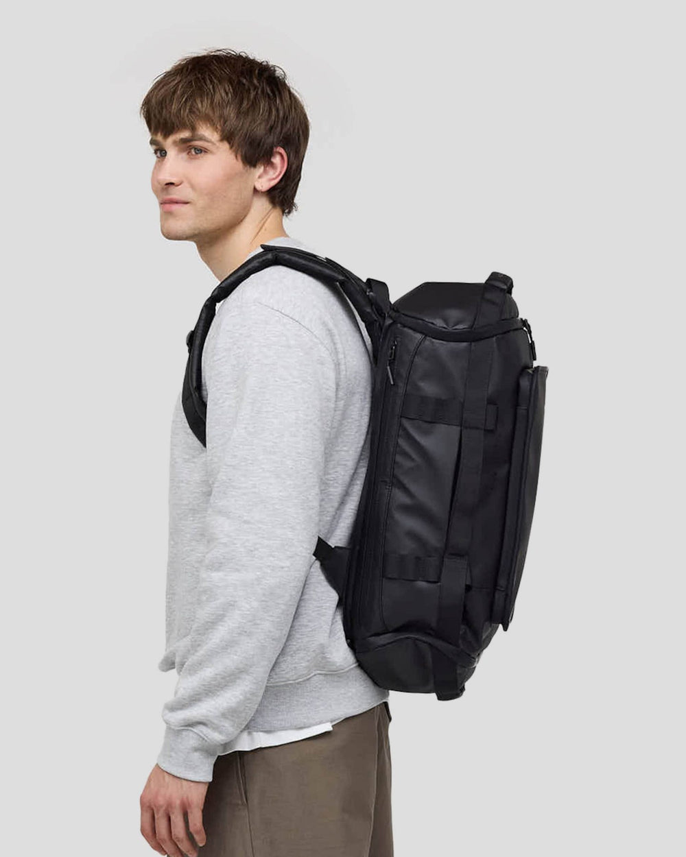 Felix, 1.85&nbsp;m, wearing the black Lisbon Duffle Backpack Small, side view