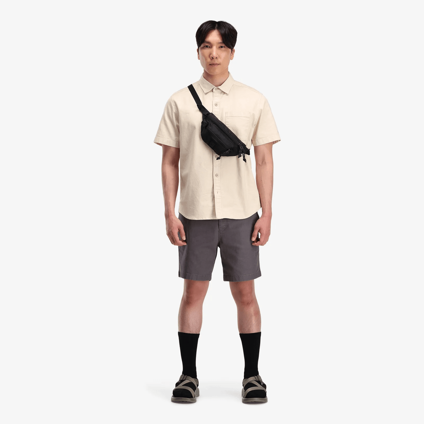 male hiker wearing black topo designs mountain waist pack as cross body bag
